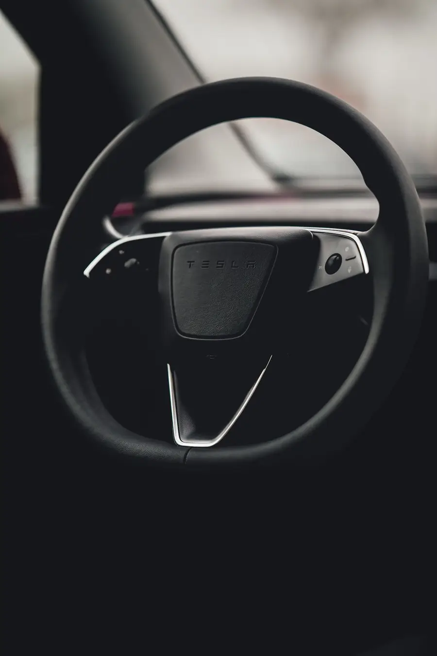 Tesla steering wheel in a dark cabin